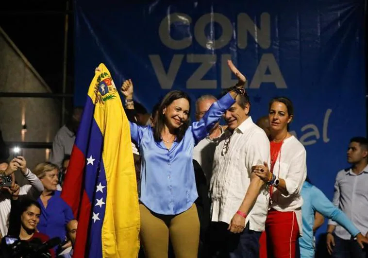 María Corina Machado celebra su victoria en las primarias envuelta en una bandera venezolana.