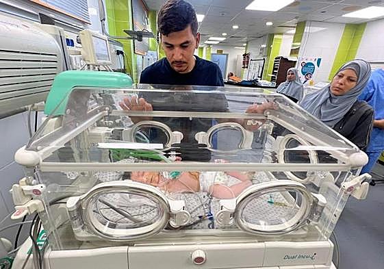 Un padre hace guardia del lado de su hija recién nacida, que recibe cuidados en una incubadora del hospital de Rafah.