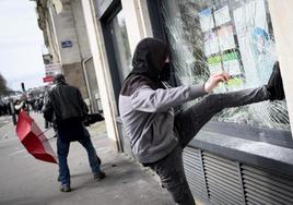 Un joven rompe el escaparate de un comercio durante unas protestas en Nantes, el pasado marzo.