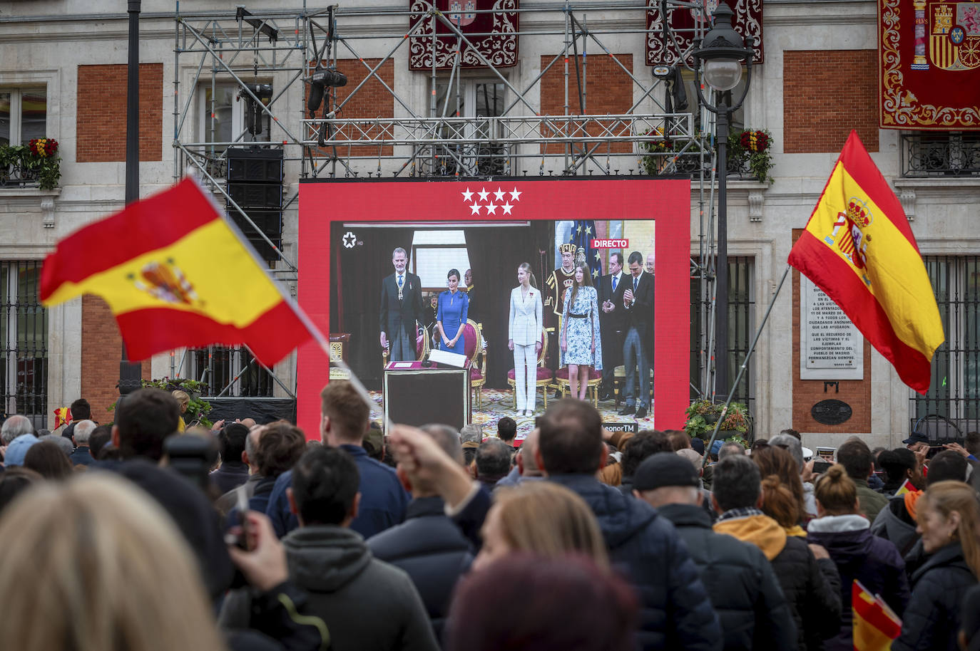 Decenas de personas siguen en una pantalla gigante instalada en la Real Casa de Correos, sede del Gobierno de la Comunidad de Madrid, la ceremonia de jura de la Constitución