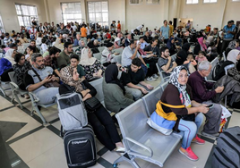 Gente esperando en el cruce fronterizo de Rafah, en el sur de la Franja de Gaza, antes de cruzar a Egipto