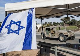 Un vehículo blindado y soldados del ejercito israelí se encuentran agrupados en una zona del frente