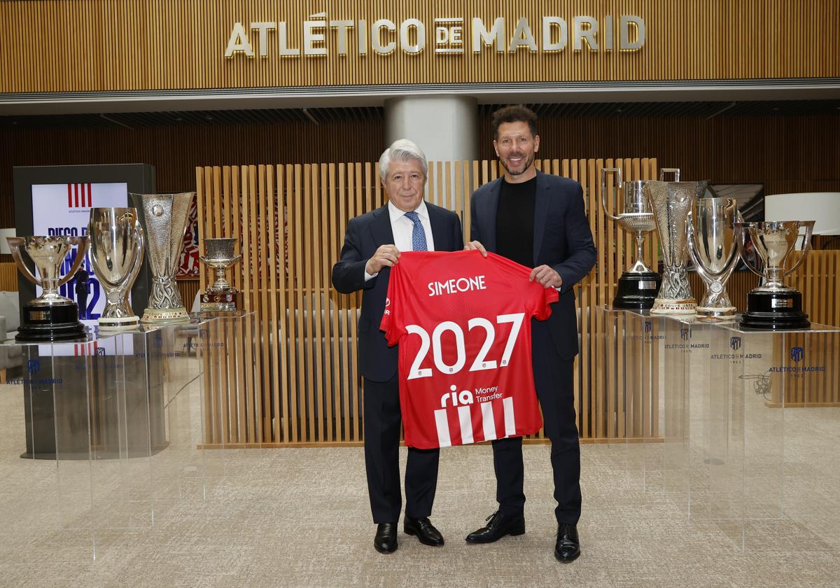 Simeone posa junto a Enrique Cerezo y los ocho trofeos que ha conquistado como técnico del Atlético.