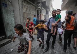 Una familia palestina corre para ponerse a salvo durante un bombardeo israelí sobre Gaza