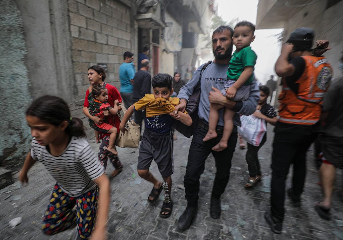 Una familia palestina corre para ponerse a salvo durante un bombardeo israelí sobre Gaza