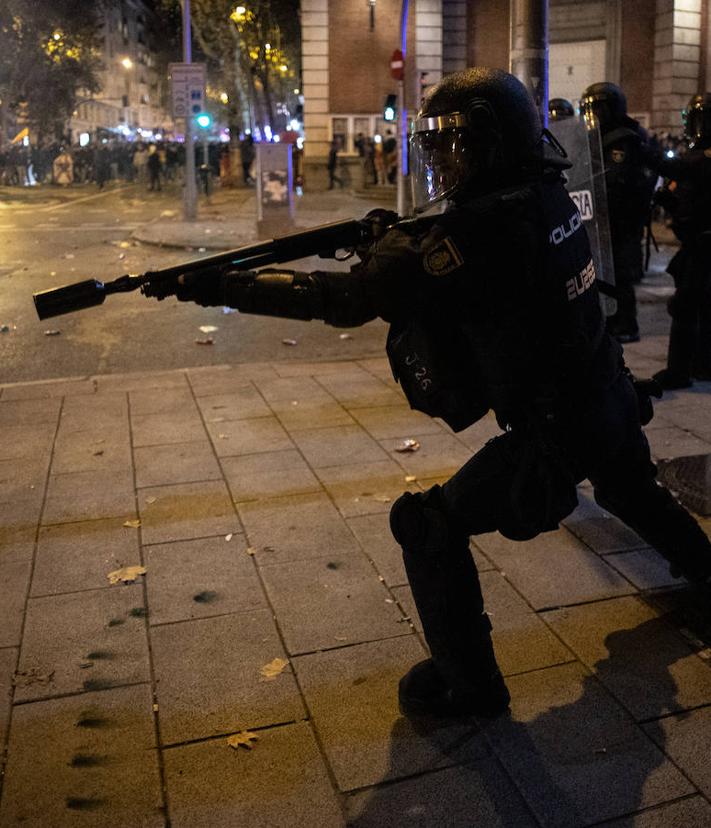 Imagen secundaria 2 - En la imagen superior, un policía intenta detener a un manifestante; debajo, un grupo de manifestantes con la bandera de España, algunos encapuchados, frente a varios agentes antidistubios; por último, un policía dispuesto a lanzar pelotas de goma tras producirse los primeros altercados violentos. 