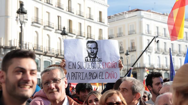 Un hombre lleva una pancarta contra Pedro Sánchez.