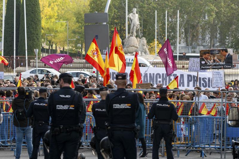 Varios policías desplegados ante un grupo de opositores a la investidura del líder socialista Pedro Sánchez que se manifiestan en los alrededores del Congreso.