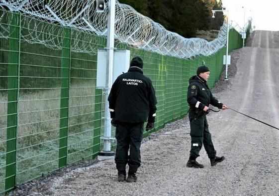 Dos guardias fronterizos de Finlandia vigilan uno de los pasos hacia Rusia.