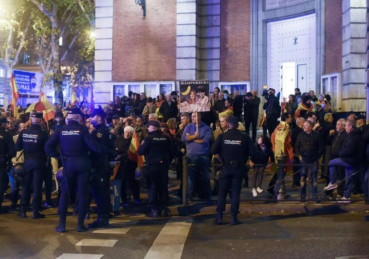 Los policías tratan de que los manifestantes contra la amnistía no salgan de la acera cerca de la madrileña calle Ferraz y puedan cortar el tráfico.