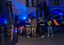 Efectivos de la Policía Nacional registran este martes una vivienda del centro de Lanjarón (Granada) junto a uno de los dos detenidos.