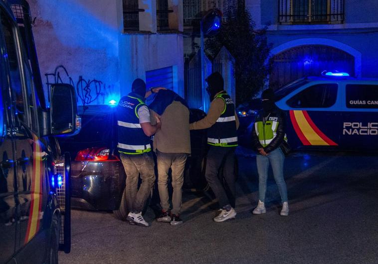 Efectivos de la Policía Nacional registran este martes una vivienda del centro de Lanjarón (Granada) junto a uno de los dos detenidos.