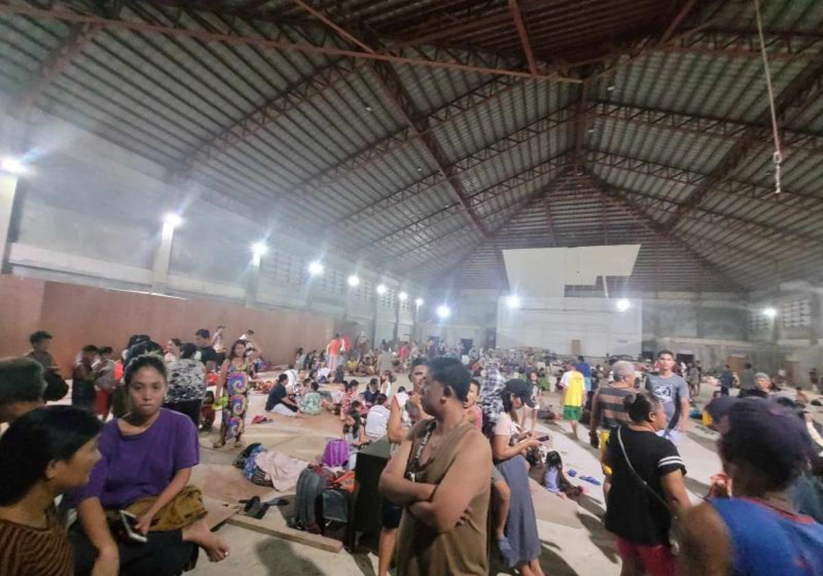 Personas evacuadas de sus hogares por la alerta de tsunami, refugiadas en un pabellón.