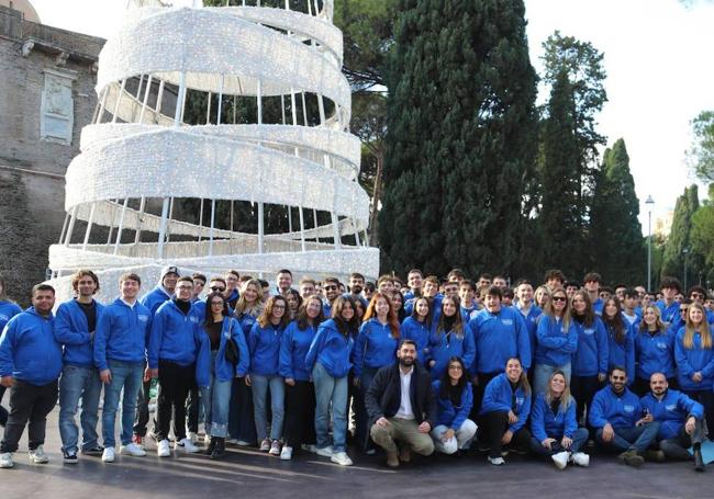 Un grupo de jóvenes militantes de FdI con el 'uniforme' del partido bajo el árbol instalado durante el evento.