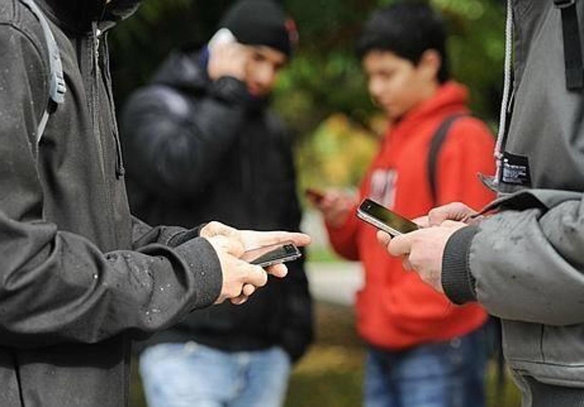 varios adolescentes con el móvil.