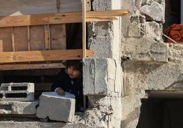 Un niño se asoma entre los escombros de un edificio destruido por ataques israelíes en Rafah