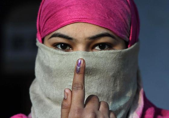 Una mujer india muestra la tinta que demuestra que ha votado.