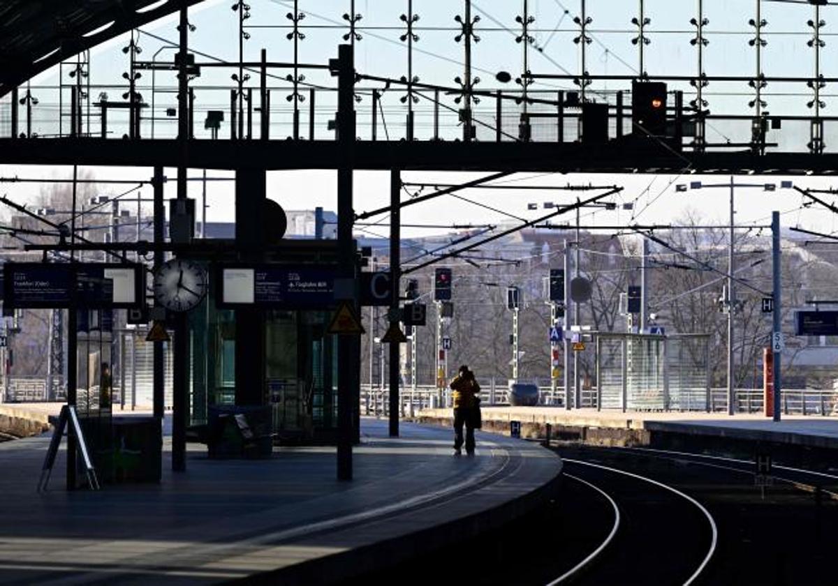 Un hombre toma fotografías a un andén desierto de la estación principal de trenes de Berlín.