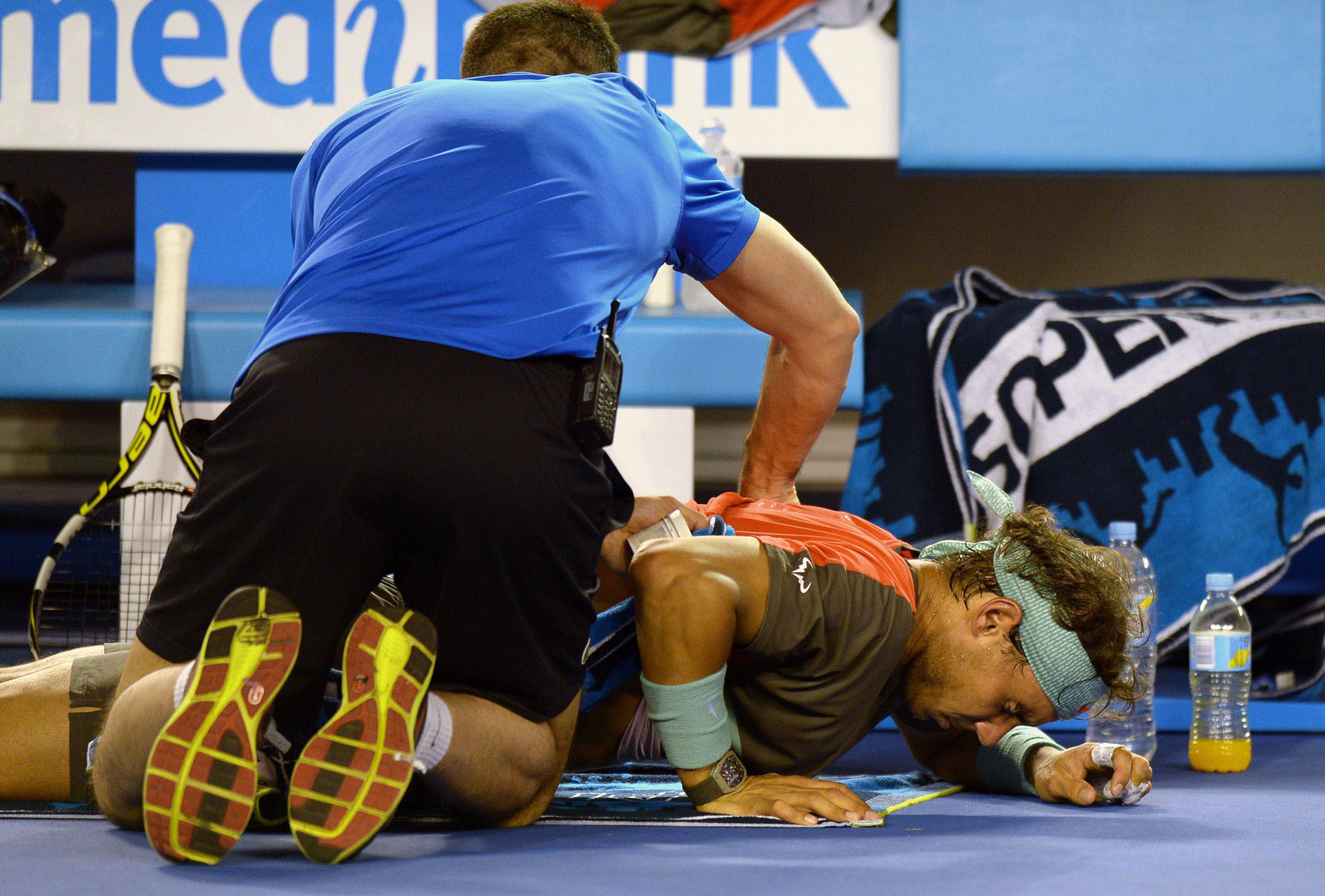 Nadal recibe un masaje en la espalda tras lesionarse en el calentamiento de la final del Abierto de Australia 2014.