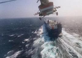 Un helicóptero militar hutí sobrevuela un buque de carga en el mar Rojo.