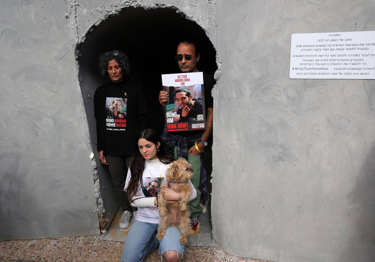 Familiares de un secuestrado por Hamás en la maqueta de un túnel levantada en Tel Aviv.