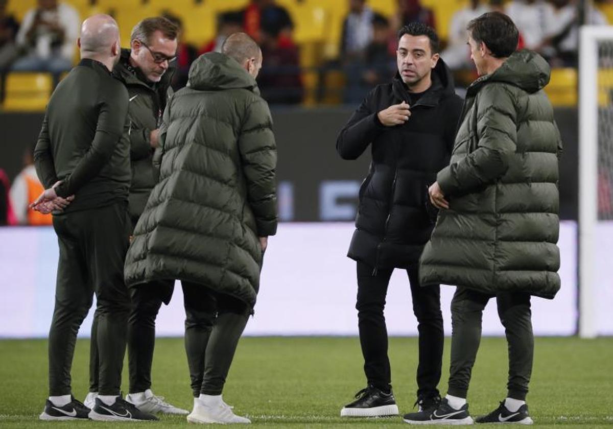 Xavi Hernández conversa con sus ayudantes.