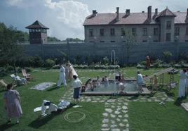 La familia del comandante Höss, a cargo de Auschwitz, disfruta del verano en su jardín, ajena al horror que tiene lugar tras la empalizada.