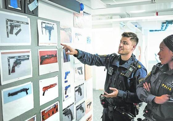 Agentes muestran imágenes de armas retenidas en la comisaría de Rinkeby.