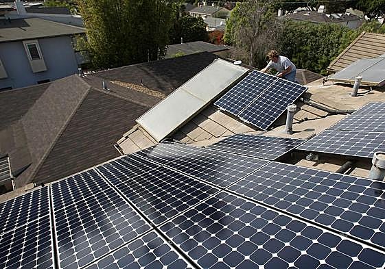 Instalación de paneles solares en los tejados de las viviendas de una zona residencial.