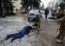 Los equipos de investigación del Ejército examinan un cadáver en una calle bombardeada en Donetsk.