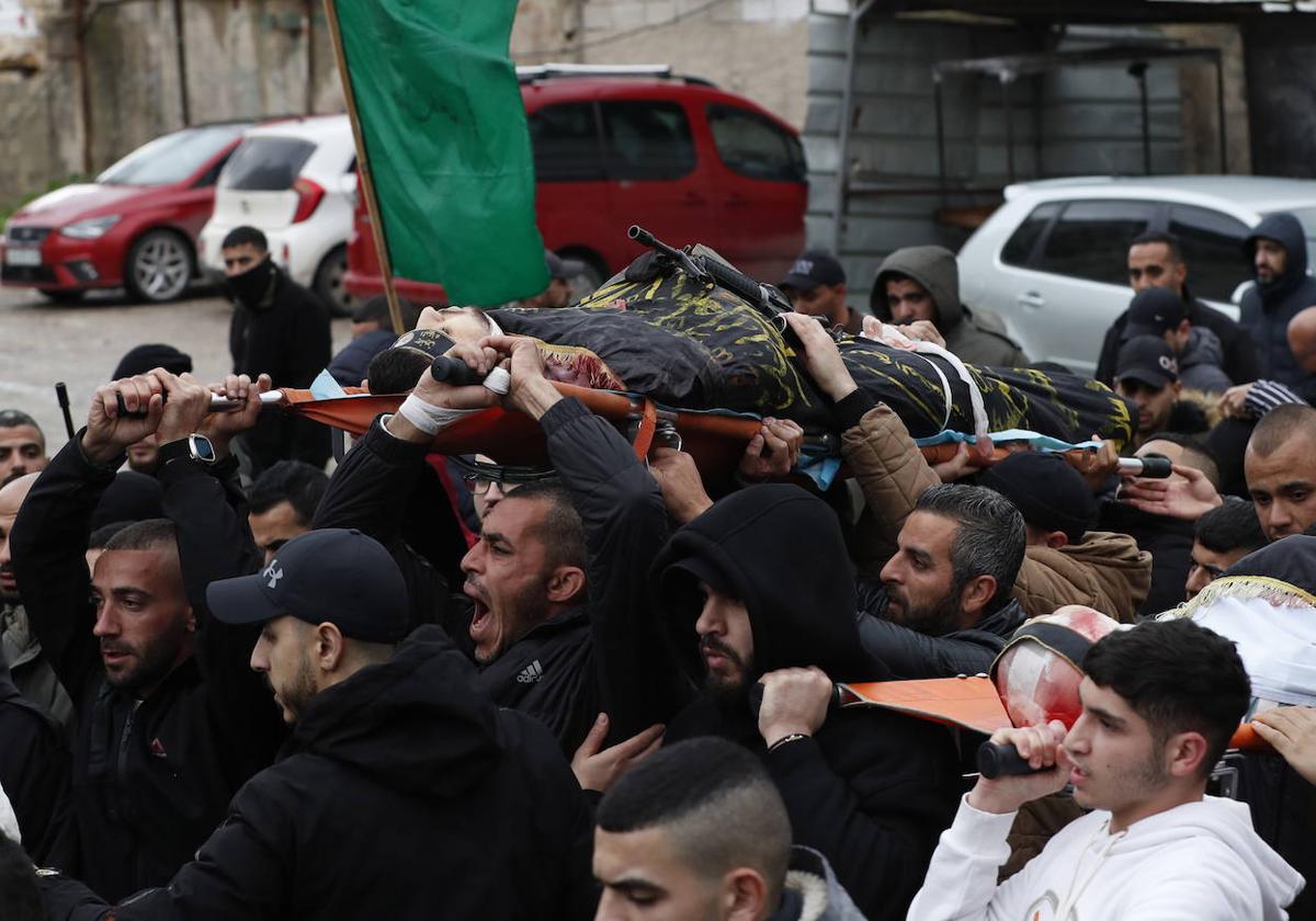 Un grupo de palestinos traslada el cuerpo de uno de los hombres asesinados en el hospital Ibn Sina de Yenín.