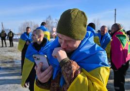 Un antiguo prisionero ucraniano sigue en su teléfono el desarrollo del nuevo canje, en que estaba incluido un familiar.