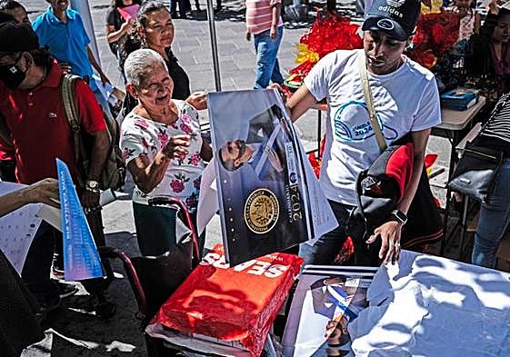 Nuevas Ideas, el partido de Bukele, reparte calendarios en una plaza en la capital salvadoreña durante la campaña electoral.