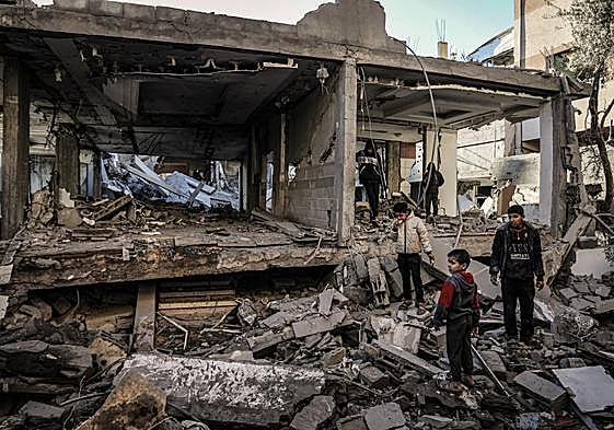 Un grupo de palestinos inspecciona los daños causados por un ataque aéreo israelí en una vivienda en Rafah.