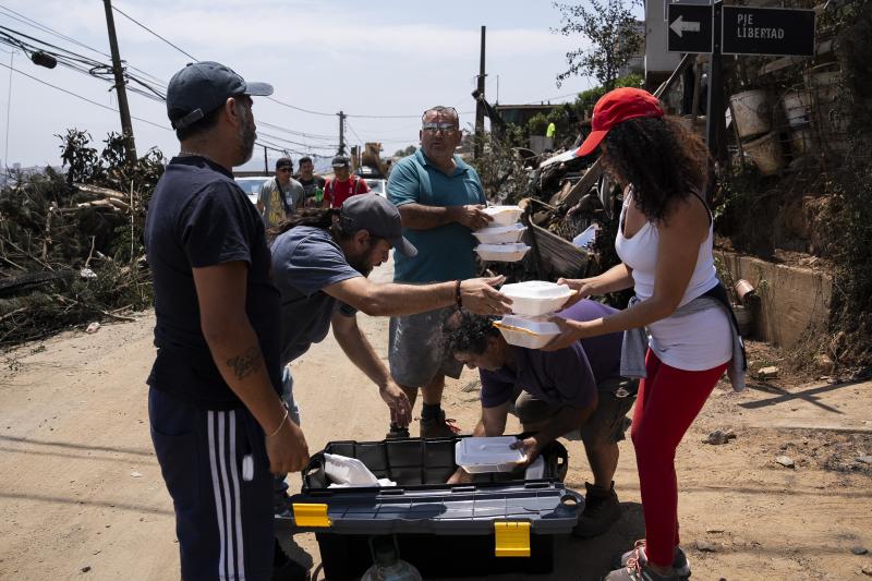 Voluntarios reparten comida a afectados por los fuegos en Viña del Mar.