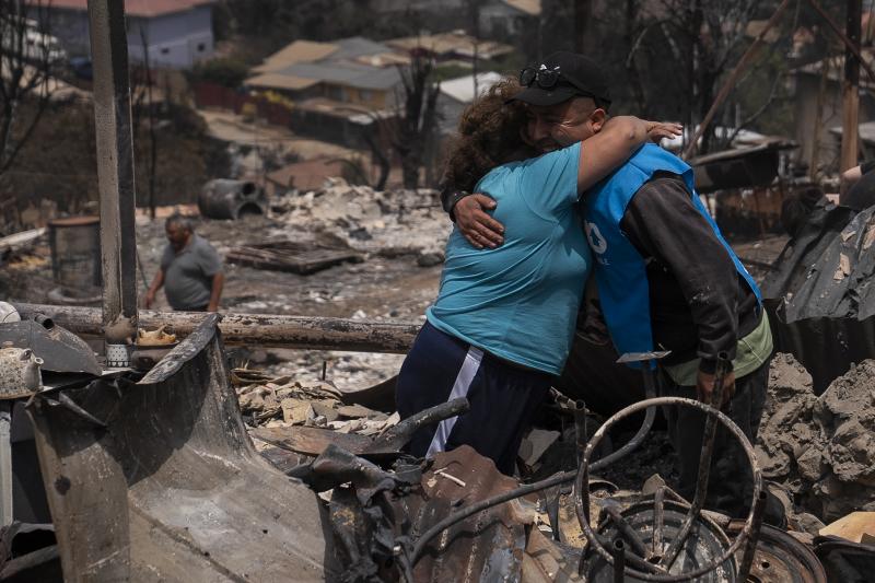 Una pareja se abraza en Achupallas, localidad afectada por los incendios forestales de Viña del Mar.