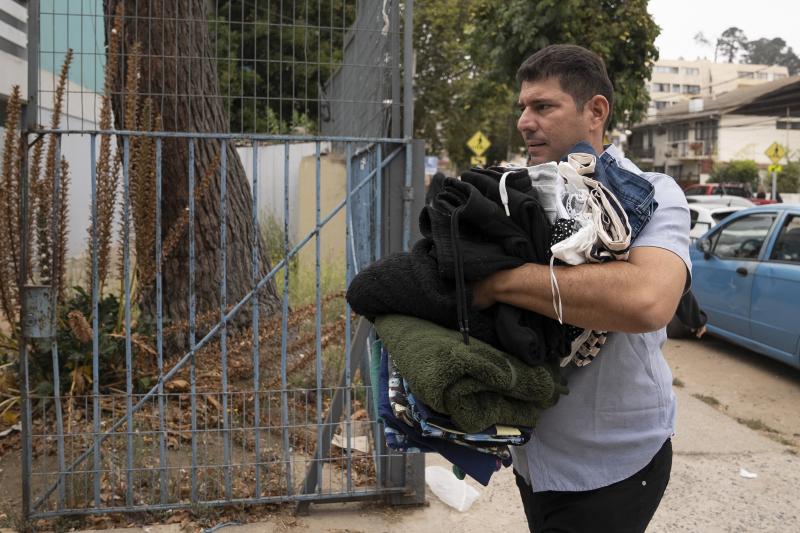 Un hombre transporta ropa a un centro de acopio en la ciudad de Viña del Mar.