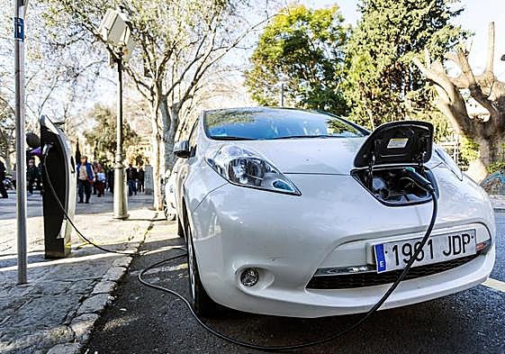 Vista de un coche eléctrico mientras carga la batería en el centro de Palma de Mallorca.