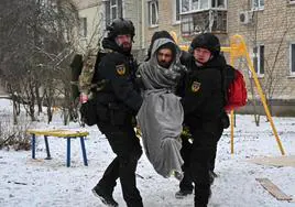 Dos policías evacúan a uno de los heridos por los bombardeos de Járkov.