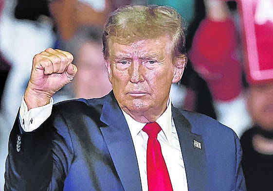 Trump realiza un gesto de fortaleza durante uno de sus últimos mítines.