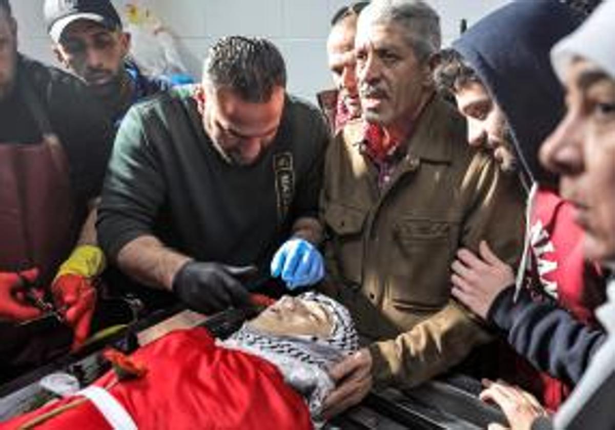 Familiares reunidos junto al cuerpo de Mohamed Ahmed durante el funeral en la morgue del Hospital Gubernamental de Ramala.