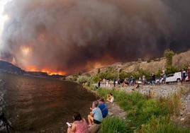 Residentes locales observan el incendio forestal que el pasado agosto azotó West Kelowna, en la provincia canadiense de Columbia Británica.