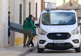 Varios agentes sacan el cuerpo sin vida de la mujer asesinada ayer en Aldea del Rey.