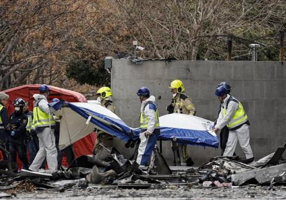 Agentes de la Policía Científica retiran con una camilla un cuerpo del edificio incendiado en el barrio de Campanar de Valencia.