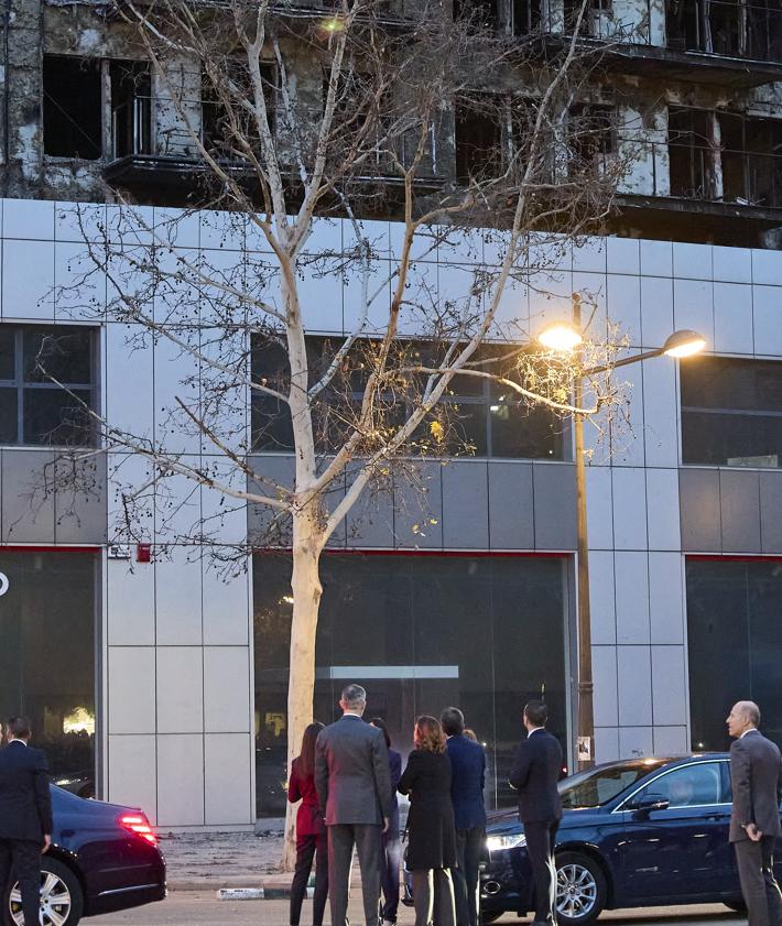 Imagen secundaria 2 - Los Reyes saludan a los cuerpos de emergencias que trabajan en el edificio incendiado y saludan a los vecinos afectados.