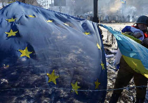 Manifestante con la bandera europea y la bandera ucraniana, en las barricadas en Kiev