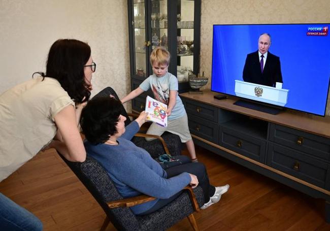 Una familia sigue en directo el discurso de Putin a la nación.