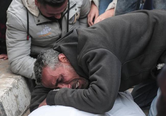 Un hombre llora sobre el cuerpo de un familiar fallecido en el bombardeo israelí.