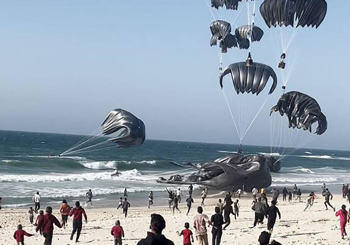 Algunos de los envíos cayeron sobre el mar. En la imagen se ve cómo gazatíes corren para recoger las cajas de ayuda humanitaria.