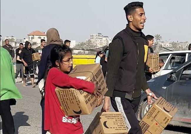 Ciudadanos gazatíes recogen los paquetes.